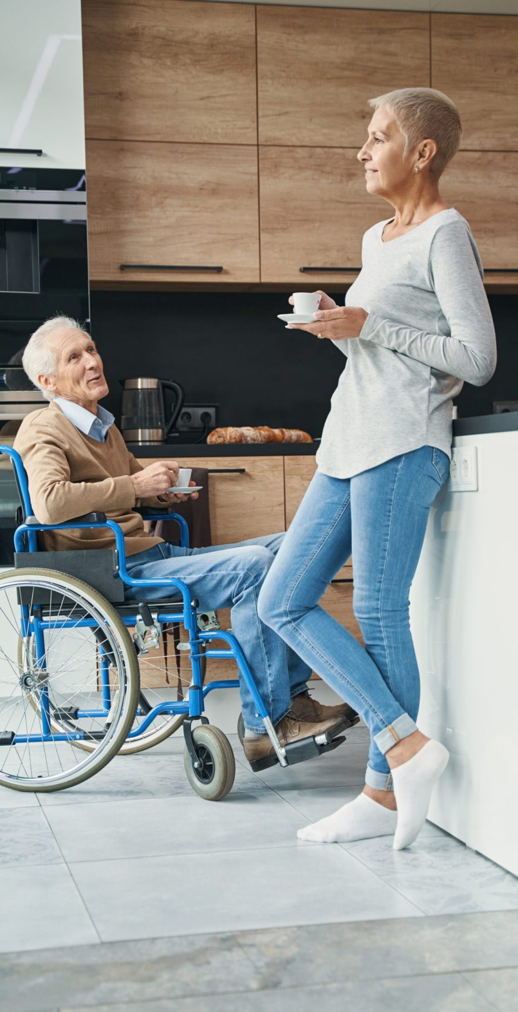 Attentive male person sitting in his wheelchair and looking at his partner